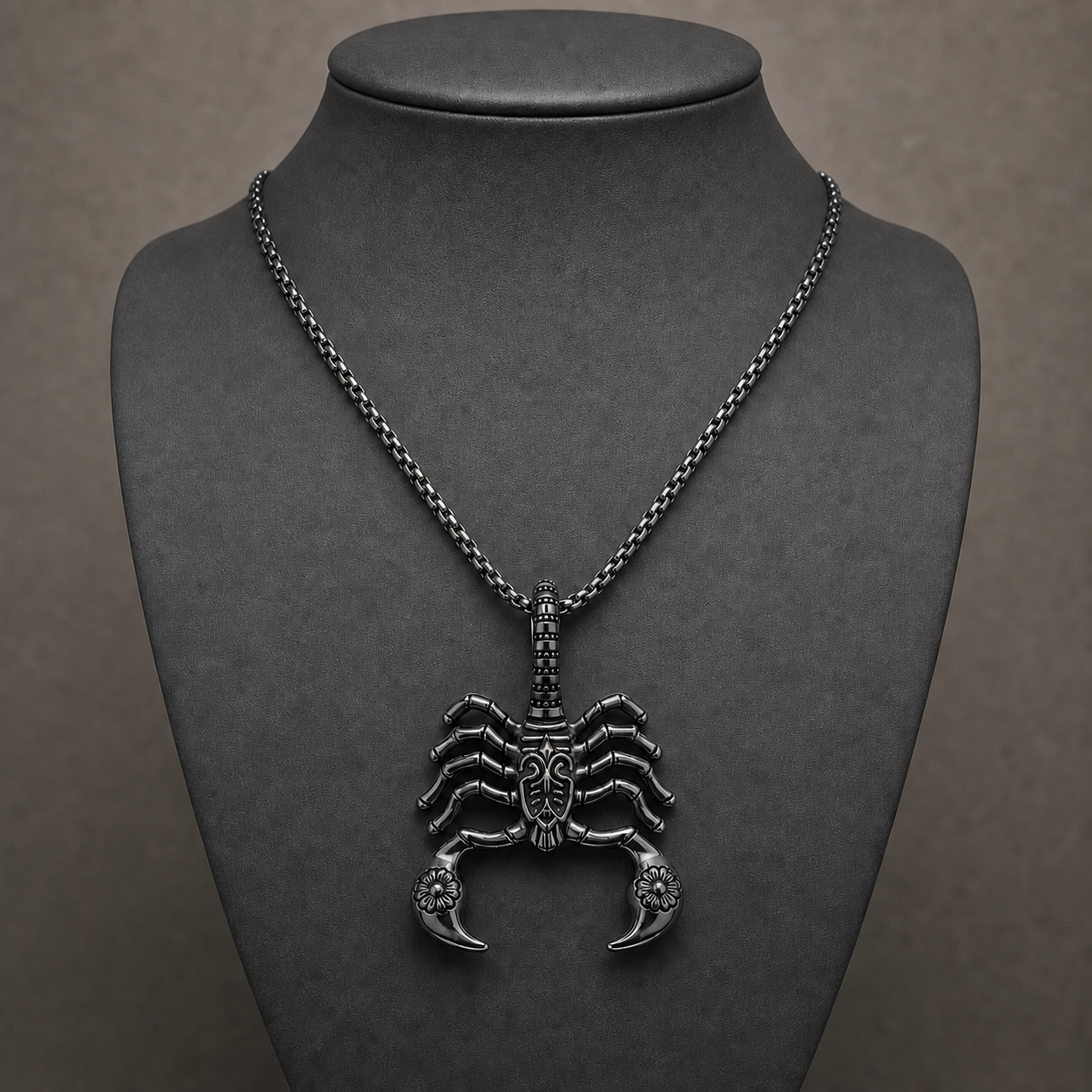Black gunmetal gothic scorpion pendant necklace displayed on a charcoal jewelry bust
