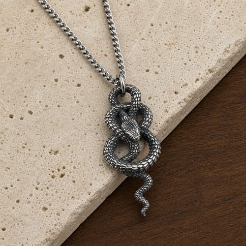 Coiled snake pendant necklace styled on travertine and walnut