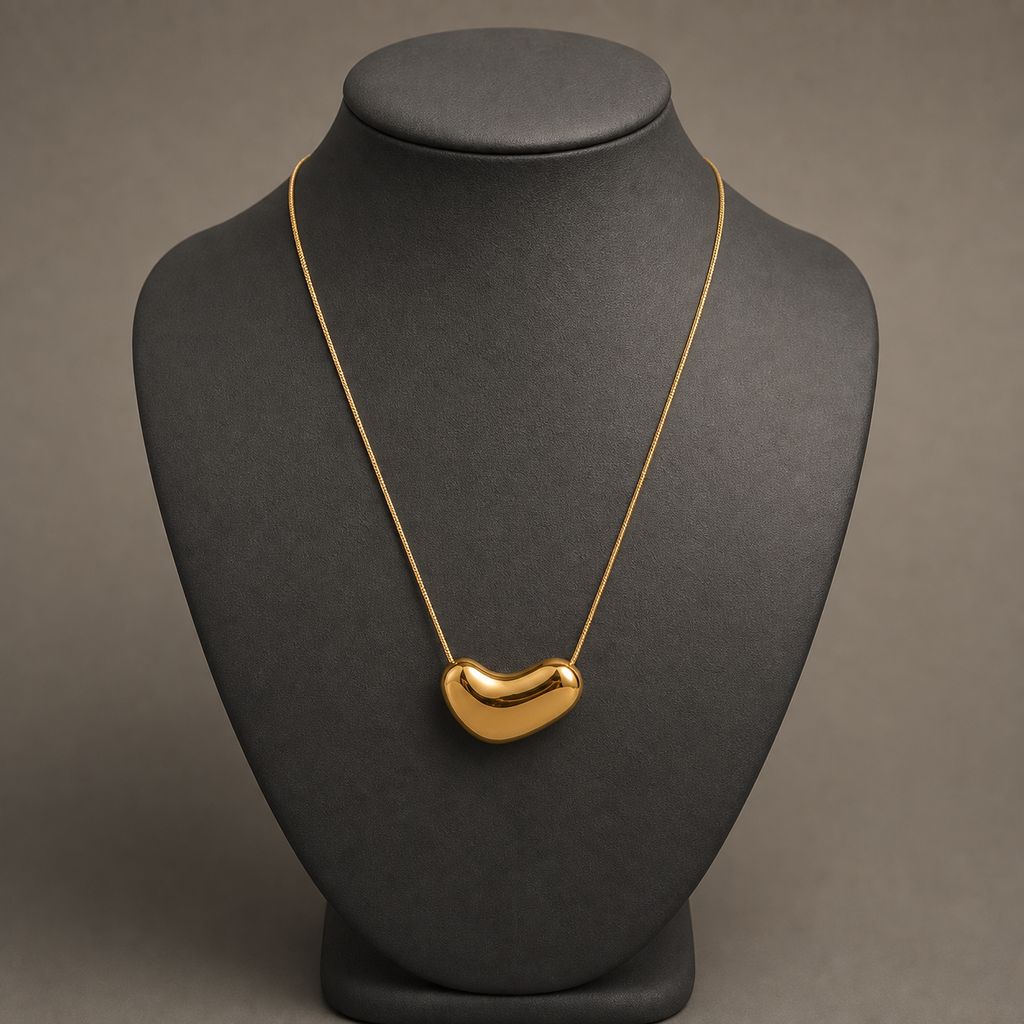 Gold irregular oval pendant on charcoal jewelry bust
