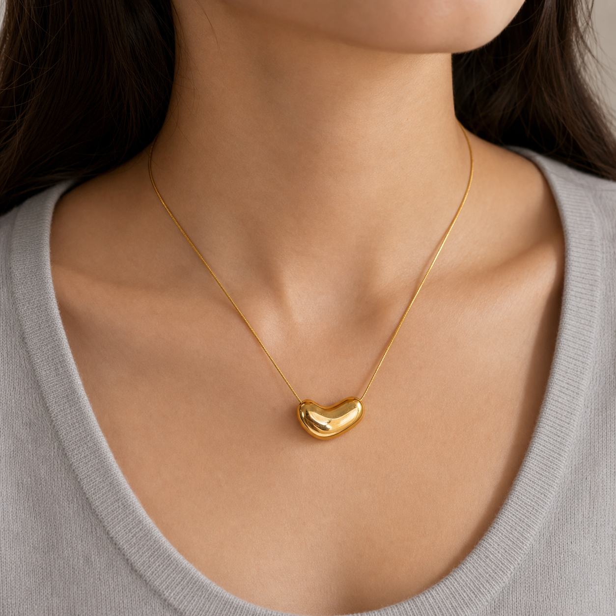 Gold irregular oval pendant necklace on model