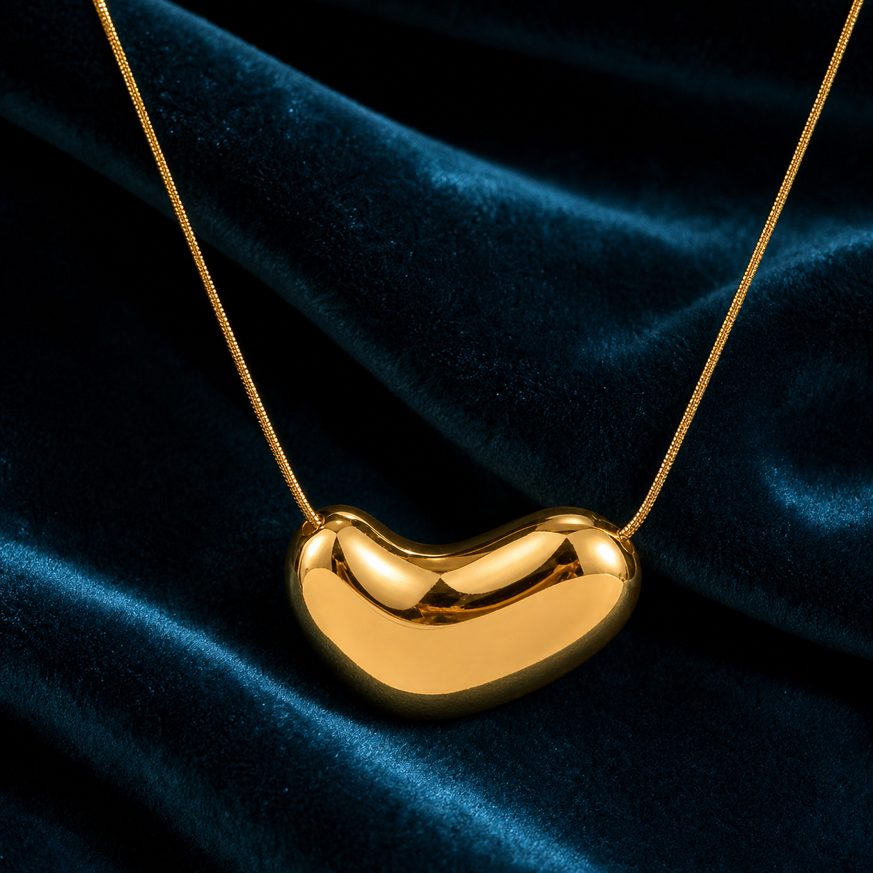 Gold irregular oval pendant on petrol velvet