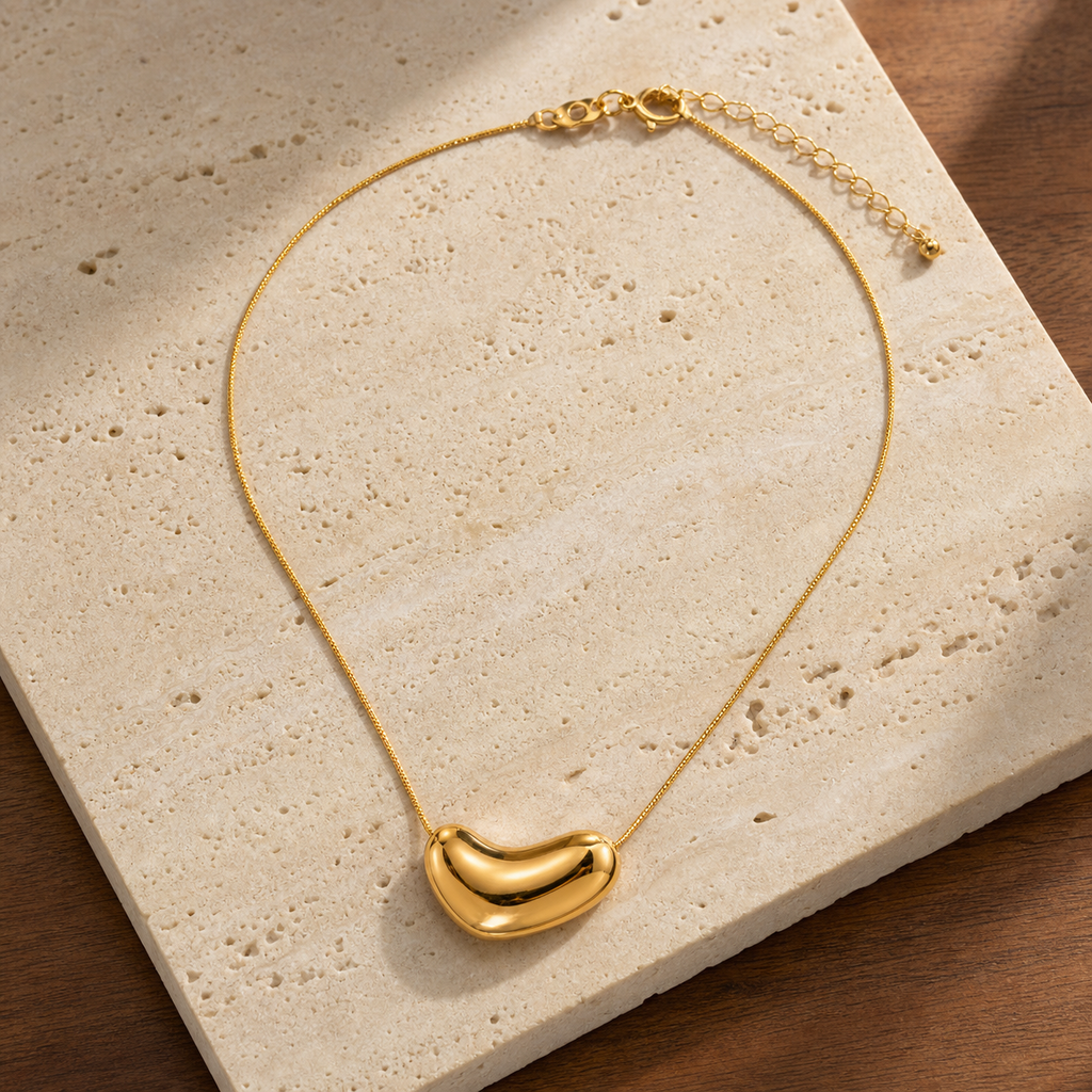 Gold irregular oval pendant flat lay