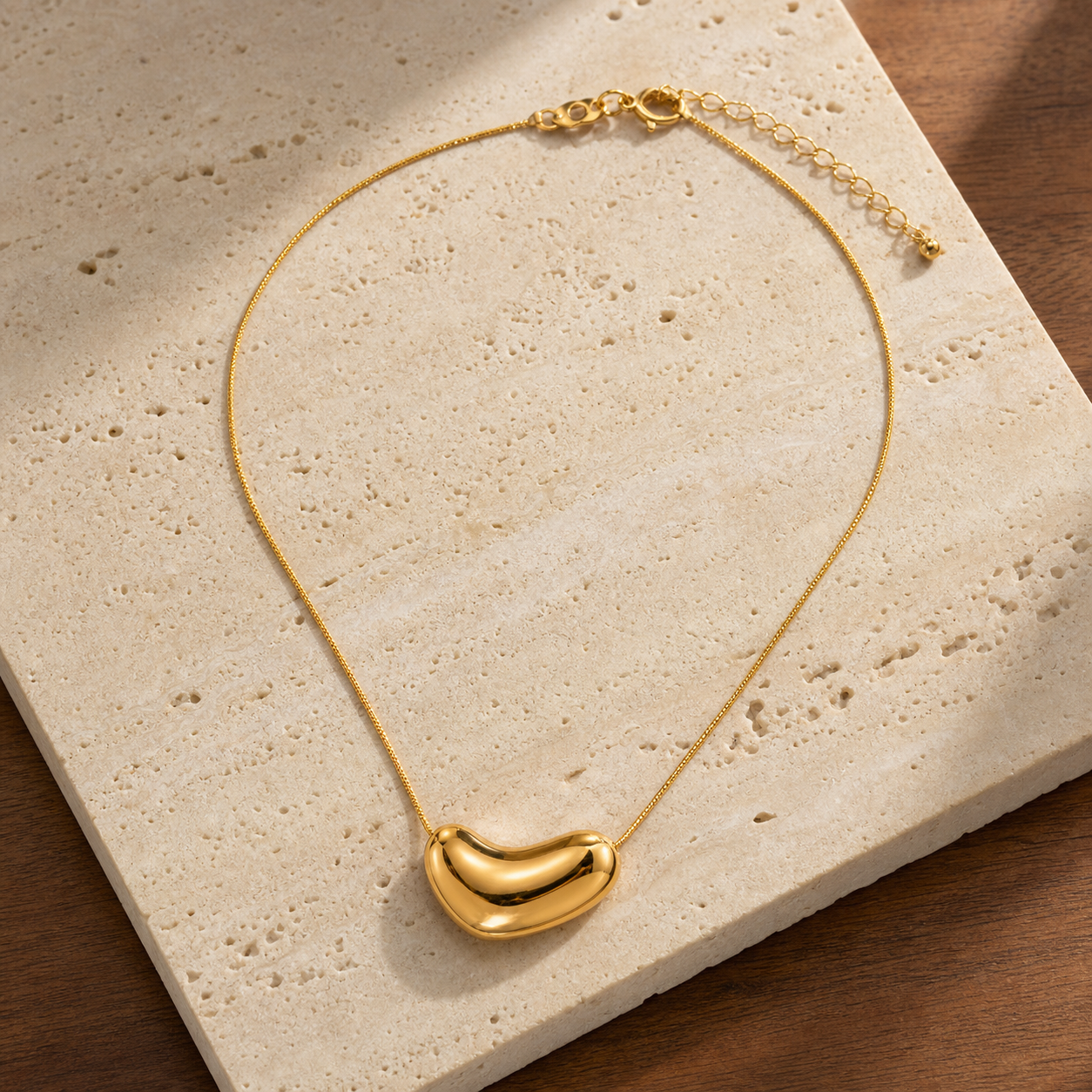 Gold irregular oval pendant flat lay