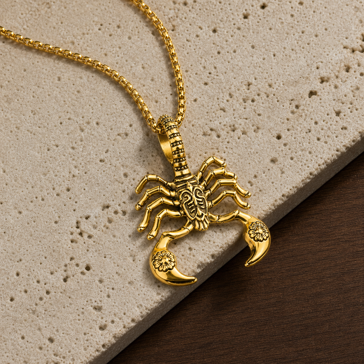 Gold scorpion pendant necklace photographed on travertine and walnut