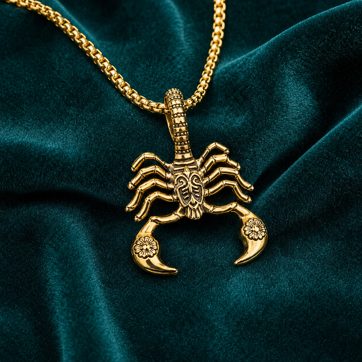 Gold scorpion pendant necklace styled on deep teal velvet
