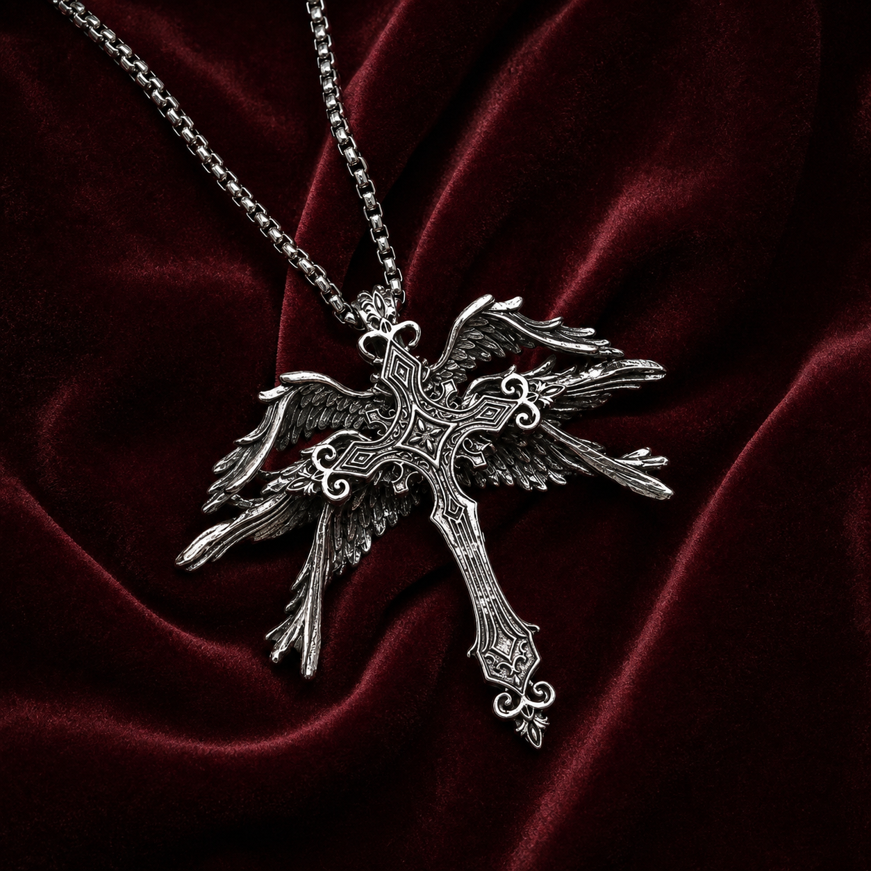 Gothic winged cross pendant necklace on rich burgundy velvet