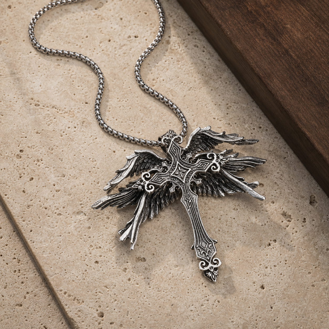 Gothic winged cross pendant necklace styled on travertine and walnut