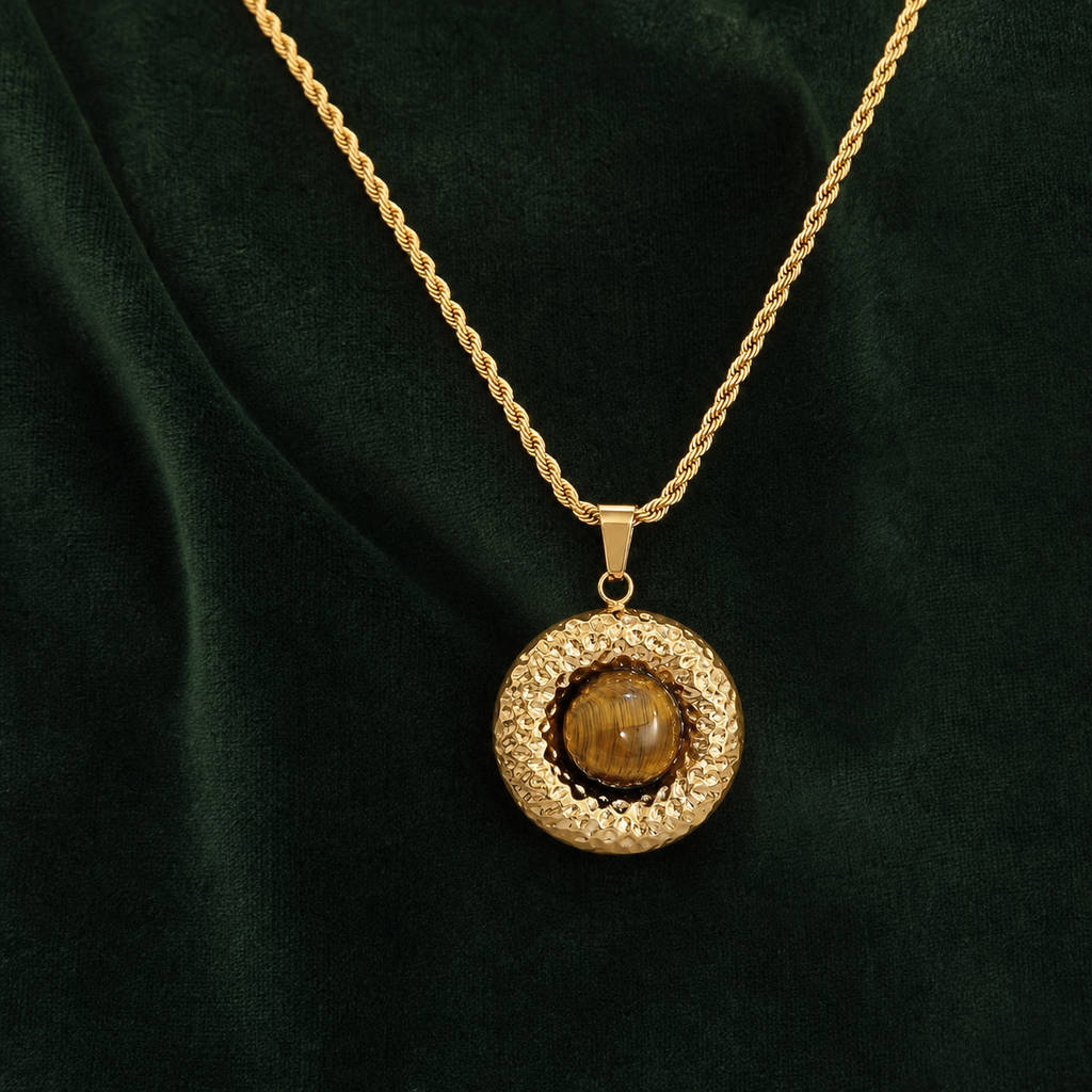 Hammered tiger-eye disc pendant necklace on deep forest-green velvet