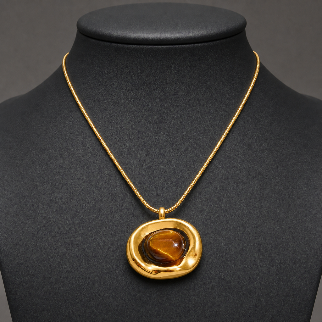 Irregular gold tiger-eye pendant necklace on charcoal jewelry bust