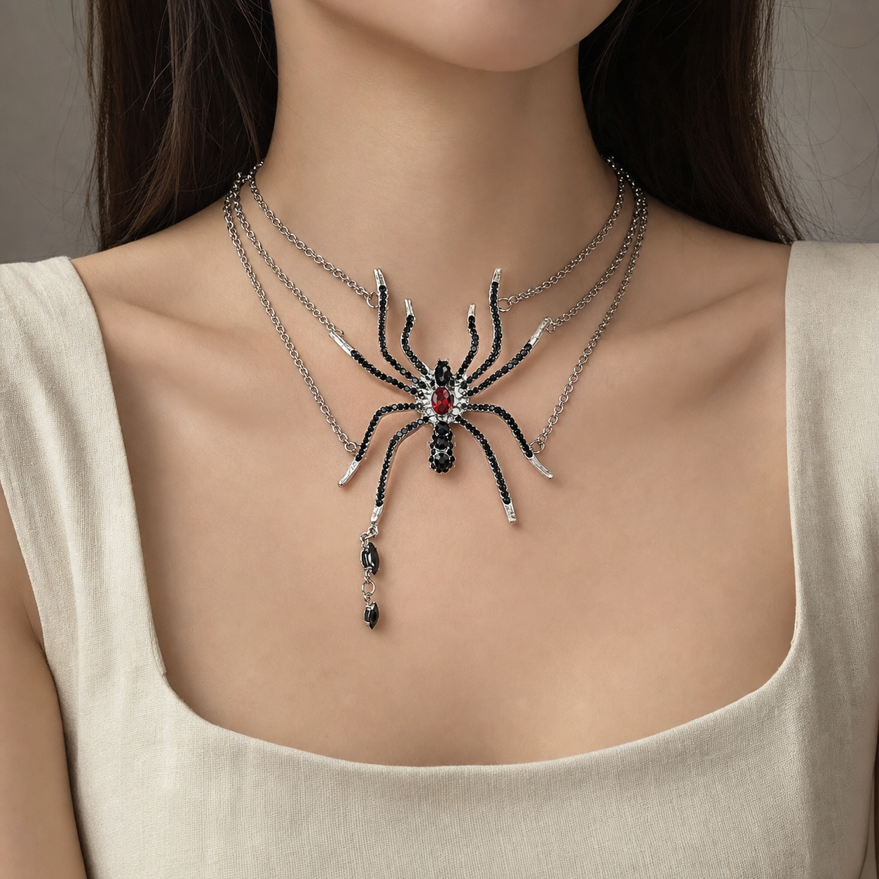 Layered gothic spider statement necklace worn with a pale stone top