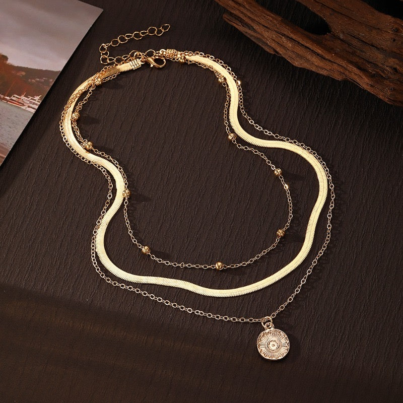 Original laid-flat view of gold three-layer round pendant necklace