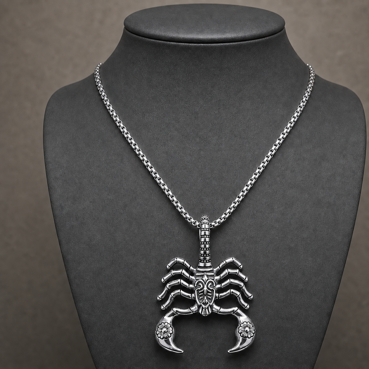 Silver gothic scorpion pendant necklace displayed on a charcoal jewelry bust