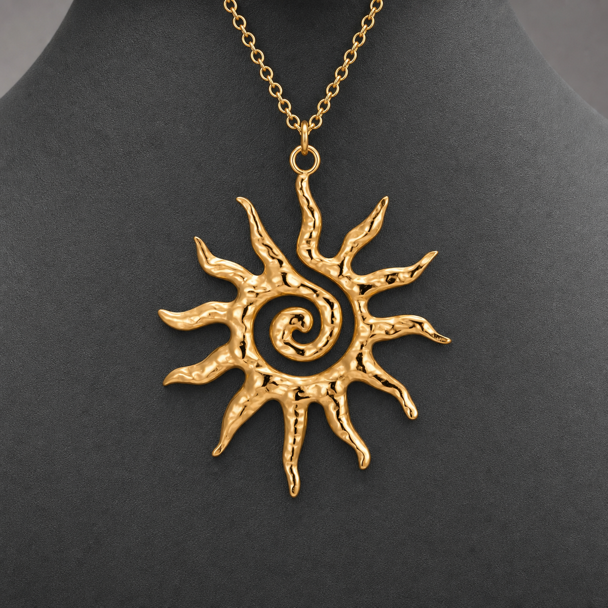 Gold textured spiral sun pendant necklace on charcoal jewelry bust