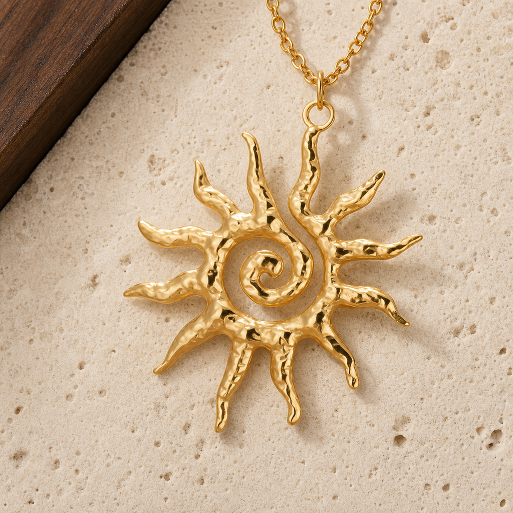 Gold textured spiral sun pendant necklace on cream travertine